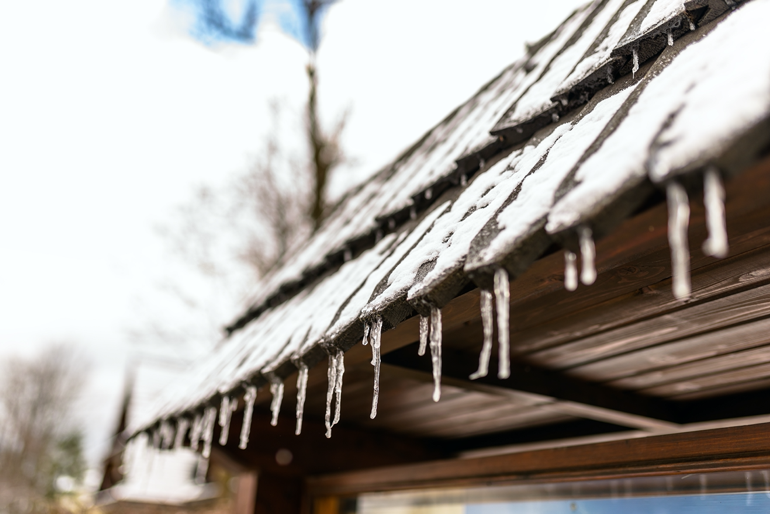 Icicles hanging from a roof shingles