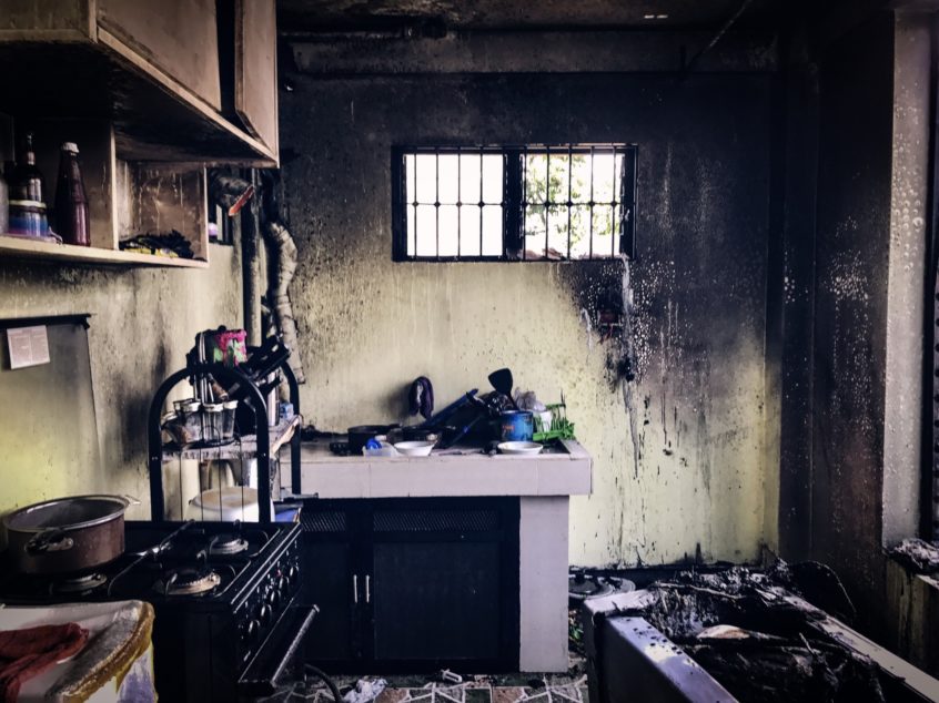 Interior of a home’s kitchen after a fire, soot-covered wall, fire damage